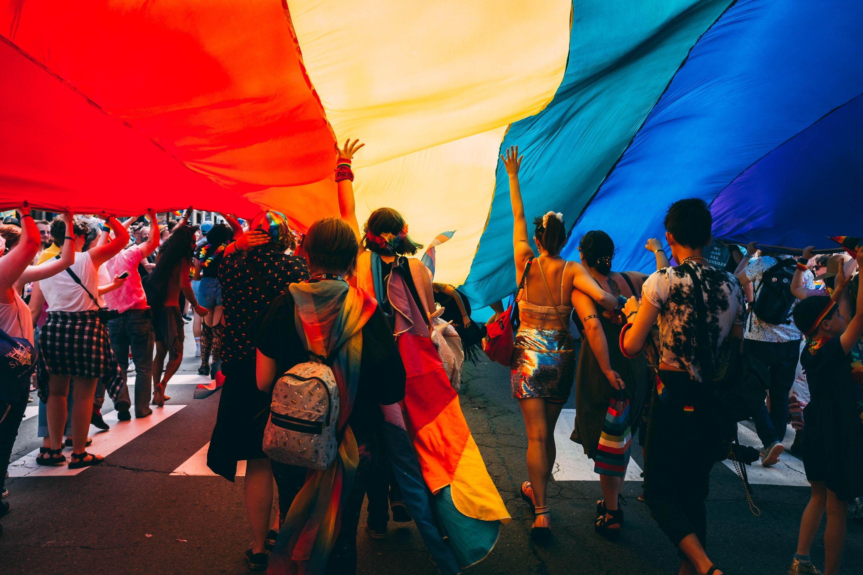 People marching under a rainbow flag